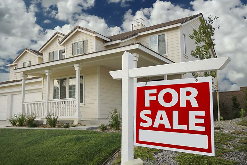 For sale sign in front of a residential property seen before home inspection services are scheduled 